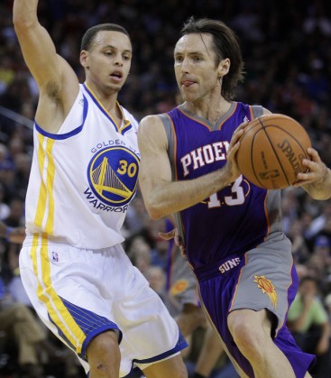 Phoenix Suns' Steve Nash, right, drives to the basket as Golden State Warriors' Stephen Curry defends during the first half of an NBA basketball game Monday, Feb. 7, 2011, in Oakland, Calif. (AP Photo/Ben Margot)